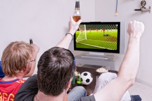 Männer schauen Fussball auf SOfa
